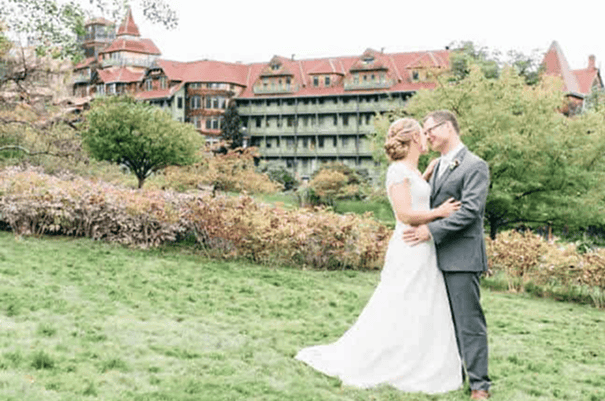 A couple standing outside with Mohonk Mountain House in the background